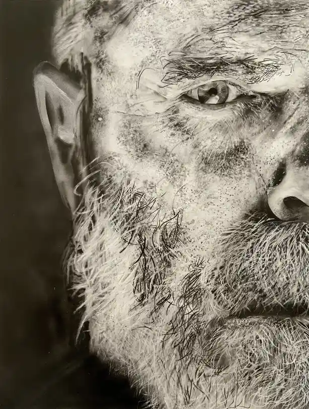 A highly detailed black-and-white portrait shows a close-up of an elderly man's face, focusing on his intense eye, weathered…