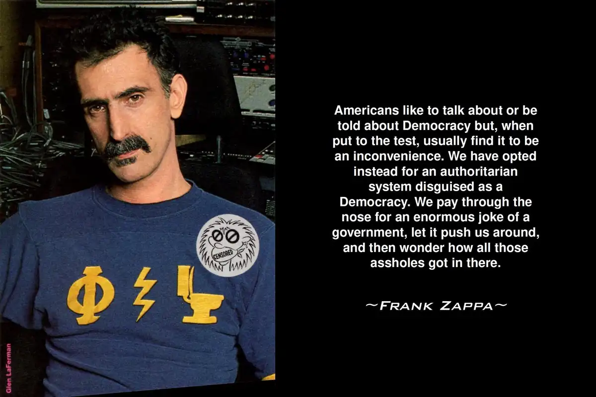 A photograph of Frank Zappa wearing a blue t-shirt with yellow symbols and a 'CENSORED' patch, set against a background of…