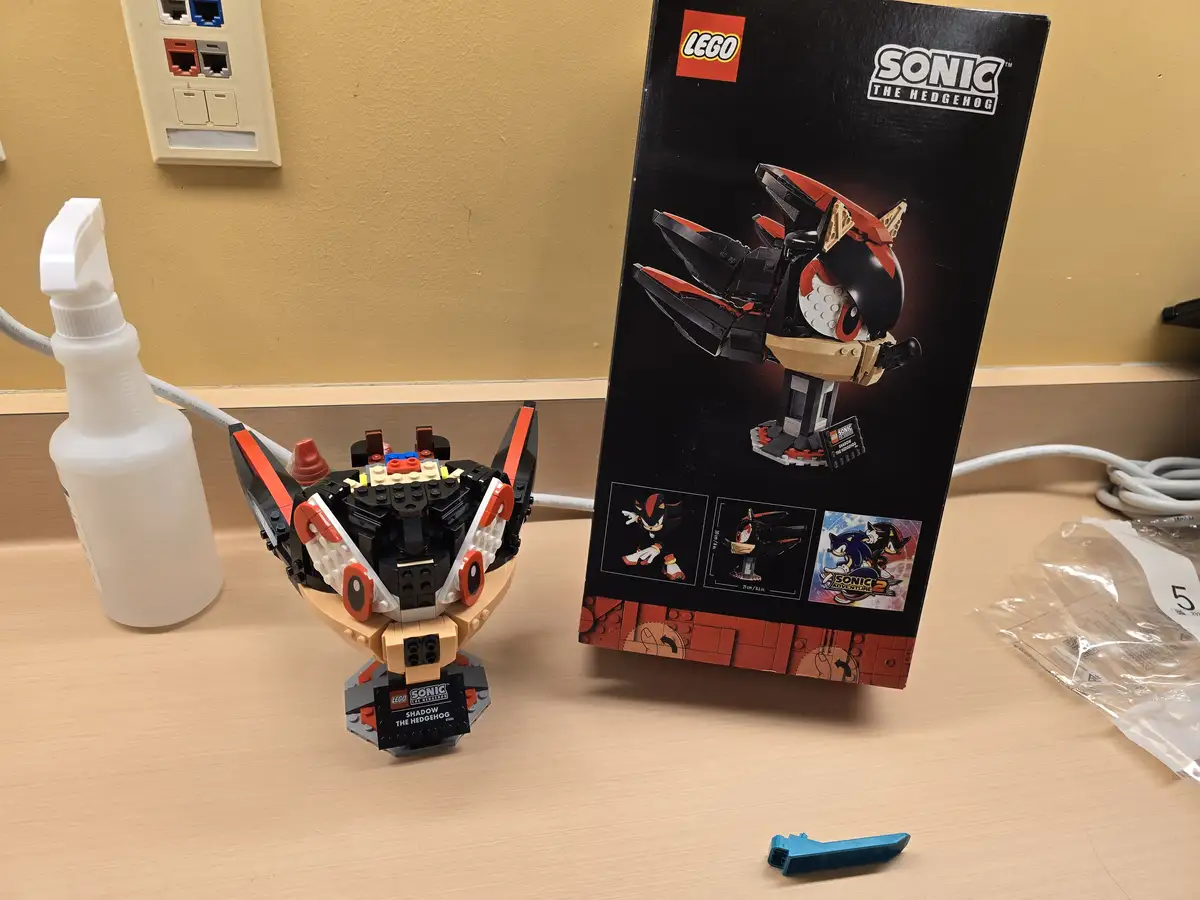 A completed LEGO Sonic the Hedgehog Shadow the Hedgehog set sits on a desk next to its box, resembling a bowl of cereal with…