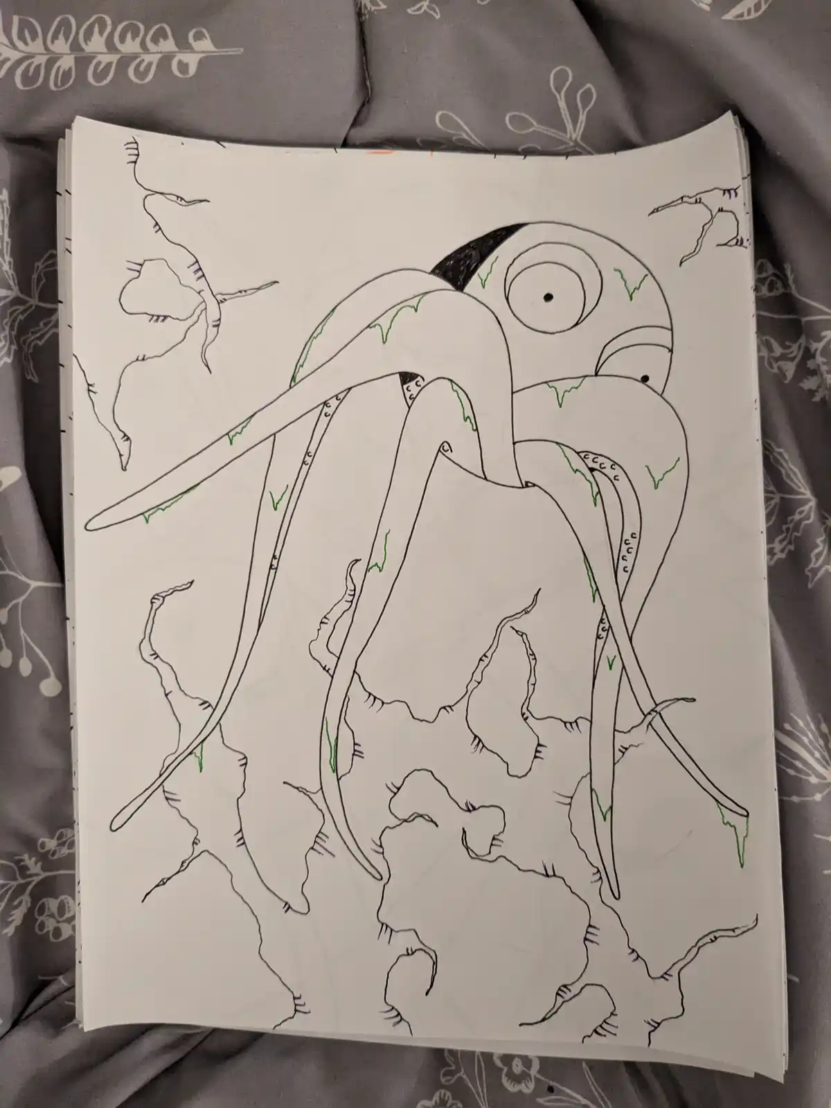 A hand-drawn sketch on white paper depicts a large, cartoonish octopus-like creature with one large eye and multiple…