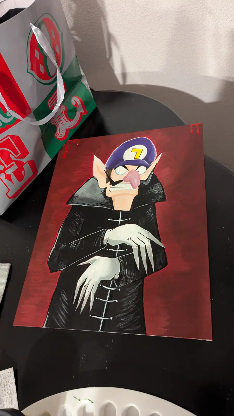 A hand-painted artwork depicts a stylized, vampire-like Wario with sharp fangs, white gloves, and a purple cap with a yellow…
