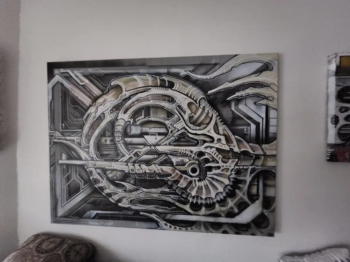 A large, detailed painting of a biomechanical, sci-fi creature with intricate metallic and organic designs hangs on a white…