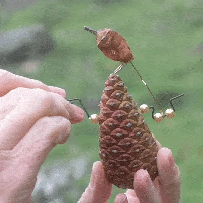 A six-panel image shows a person's hands holding a pinecone that has been modified with wire and beads to resemble a…