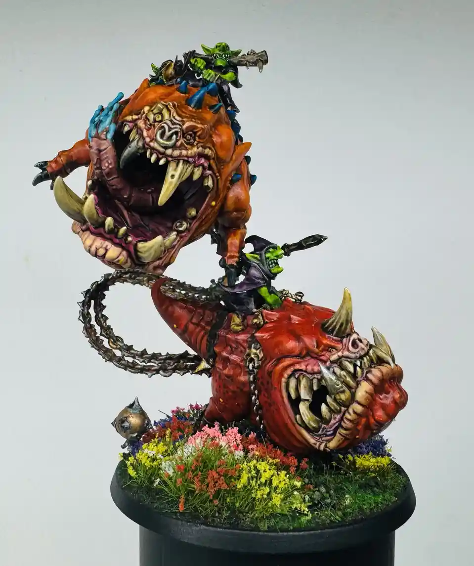 A highly detailed, painted miniature of two monstrous, grotesque, toothy creatures with green-skinned goblin riders on their…