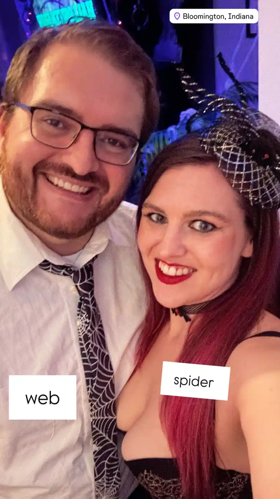 A selfie of a smiling man and woman dressed in spider-themed costumes at a party in Bloomington, Indiana. The man wears a…