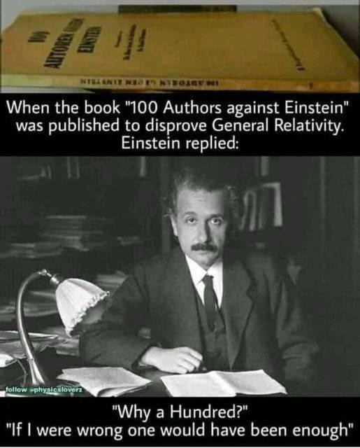 A black-and-white photo of Albert Einstein sitting at a desk with papers and a lamp, looking directly at the camera. Above…