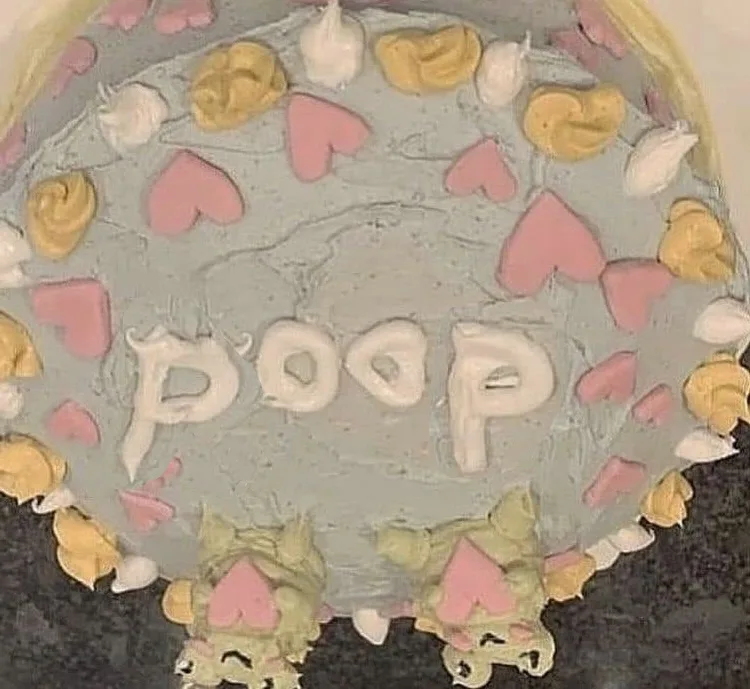 A close-up of a round cake with light blue frosting, decorated with pink heart and yellow swirl piped icing around the edge…