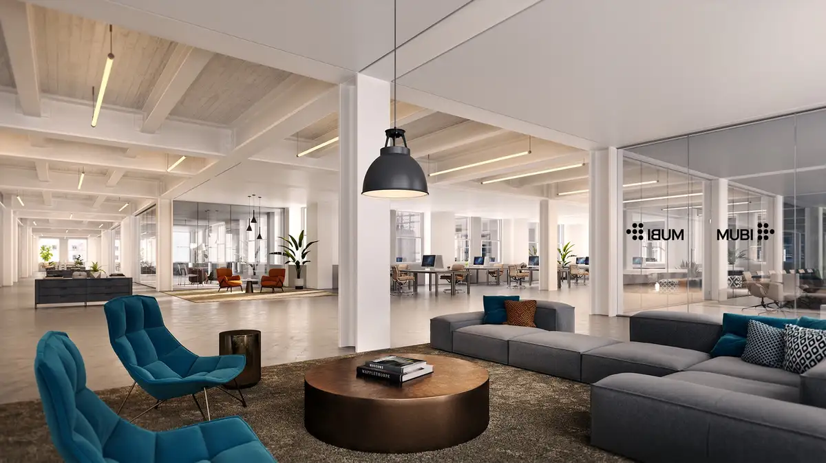A modern, spacious, and stylish office interior with exposed beams, glass-walled rooms, and contemporary furniture including…