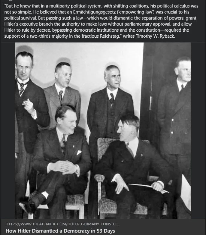 A black-and-white historical photograph shows Adolf Hitler seated and smiling while conversing with another man, surrounded…
