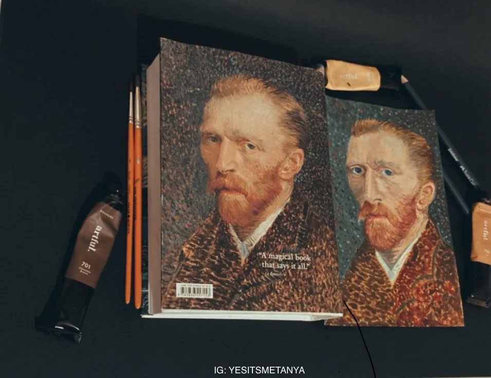 A book and a smaller card both feature a portrait of Vincent van Gogh, surrounded by art supplies like paint tubes and…