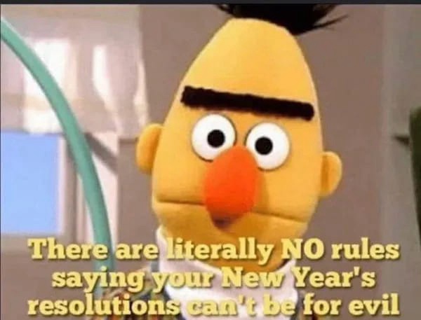 A close-up of the Muppet character Bert, who has a slightly smug or mischievous expression. He has a yellow, cone-shaped…