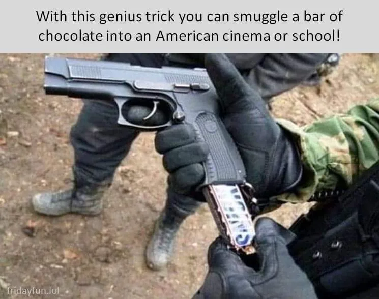 A person wearing black gloves holds a handgun, with a chocolate bar wrapped in silver foil visibly inserted into the gun's…