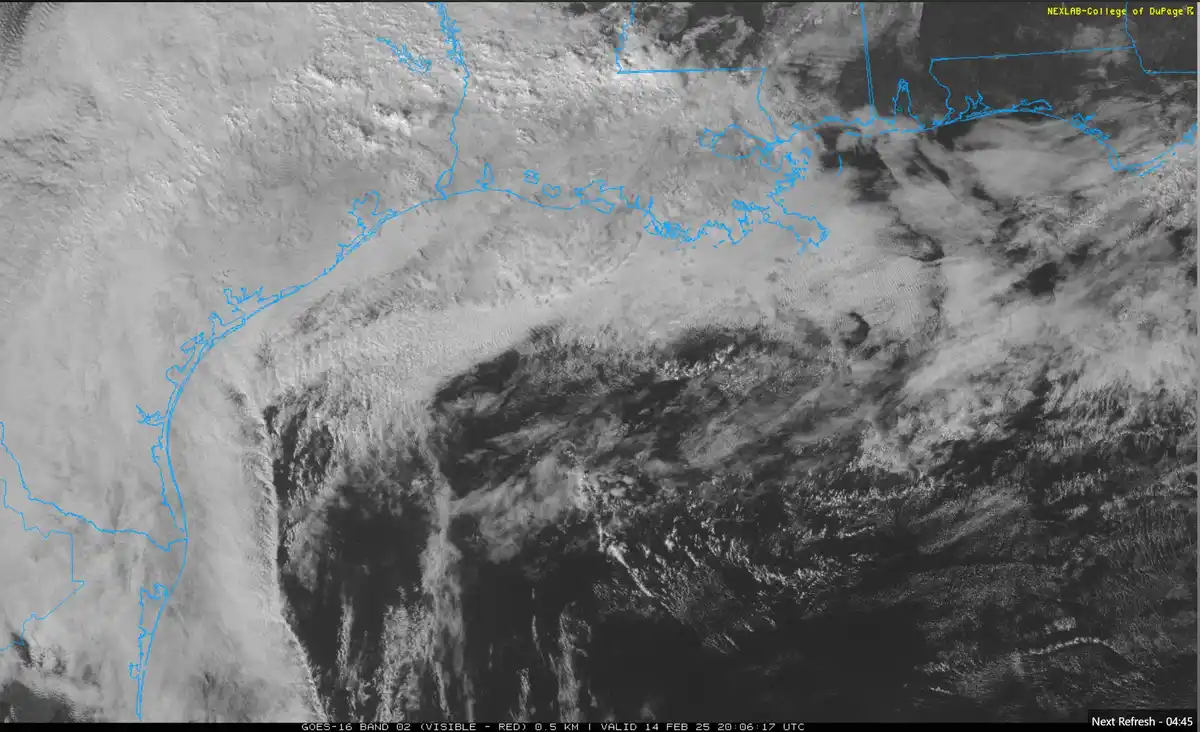 a grayscale satellite image from the goes-16 weather satellite shows a large, swirling storm system over the atlantic ocean…