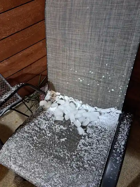 An outdoor patio chair covered in snow and ice cubes, with the overlaid text 'i'm not lazy, i'm just conserving energy'. The…