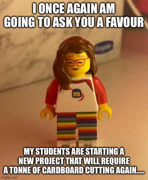 A close-up photo of a female Lego minifigure with brown hair, red glasses, a white shirt with a blue Lego logo, and…