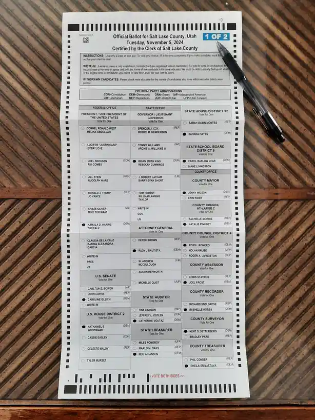 An official Salt Lake County, Utah ballot from November 5, 2024, is shown with a black pen resting on it. Several candidate…