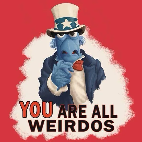 A blue Muppet character wearing a patriotic Uncle Sam top hat and suit points accusingly at the viewer. The image has a red…