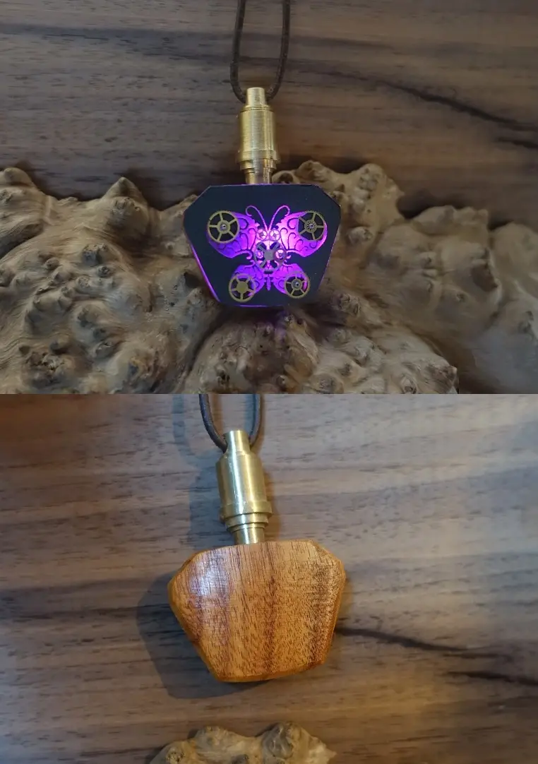 The image shows a pendant with a brass clasp and black cord, displayed in two states: top view reveals a glowing purple…