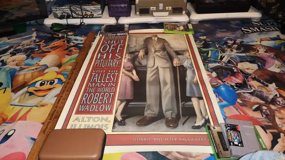 A vintage-style poster of Robert Wadlow, the tallest man in the world, is laid out on a colorful Super Smash Bros. rug…