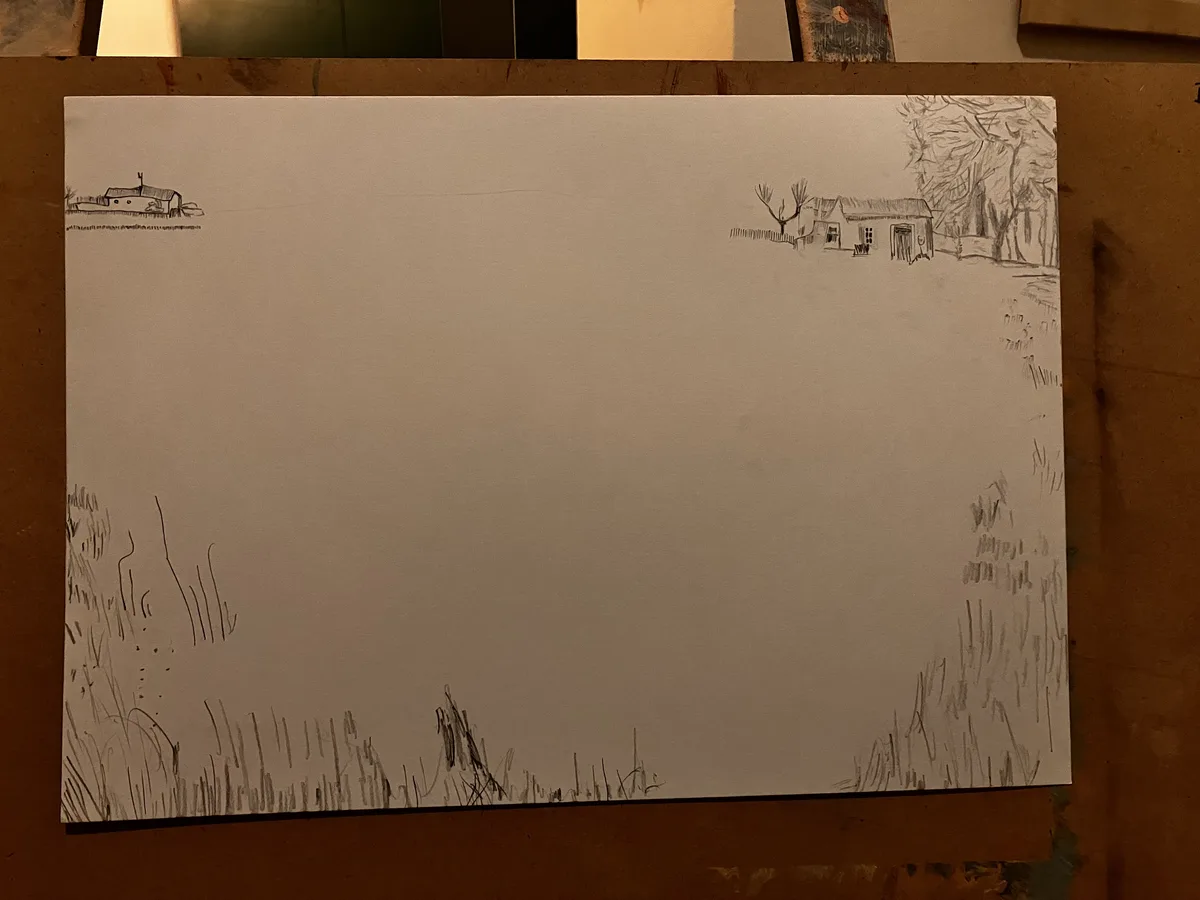 A pencil sketch on white paper shows two small houses drawn in the top corners, with scribbled grass at the bottom edges…