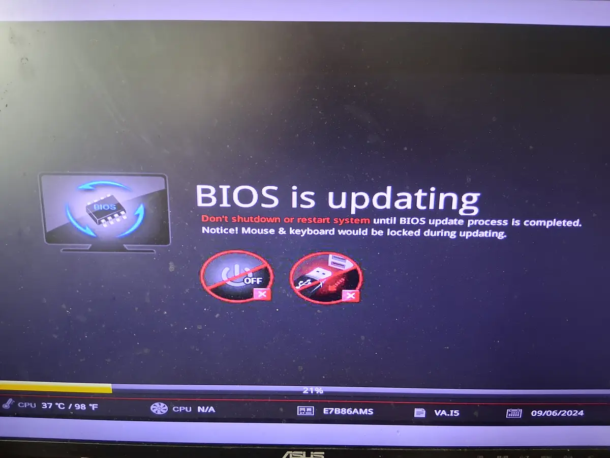 A computer screen displays a BIOS update in progress, showing a progress bar at 21%, a warning that the system must not be…