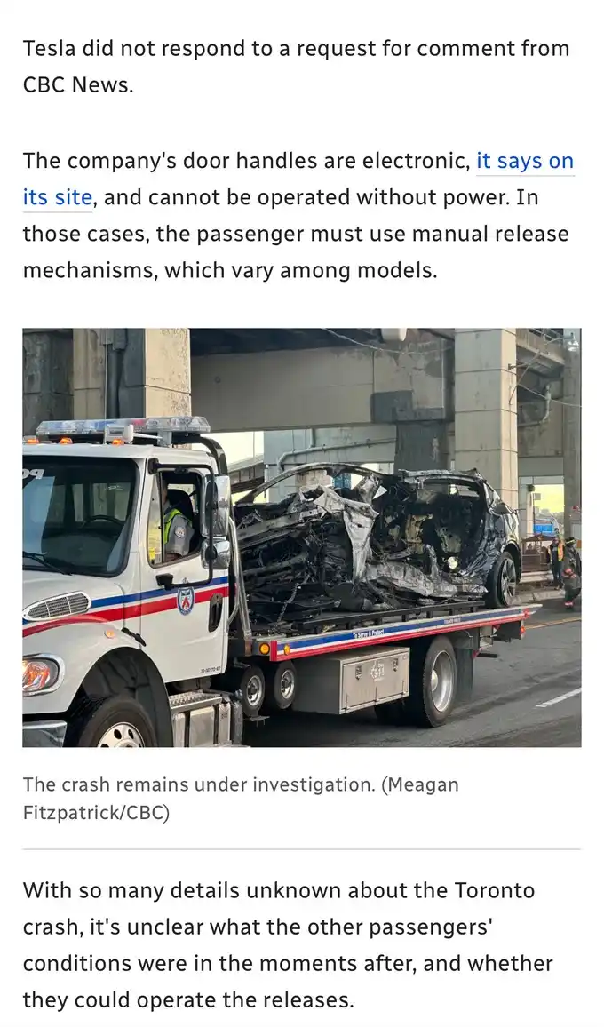 A severely damaged, burnt-out Tesla vehicle is being transported on the flatbed of a white tow truck with red and blue…