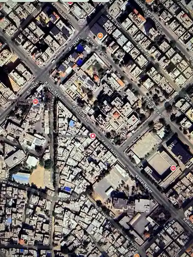 A satellite map view of a dense urban neighborhood with streets like Kamal Naser and Deir Yassin, showing a hospital and…