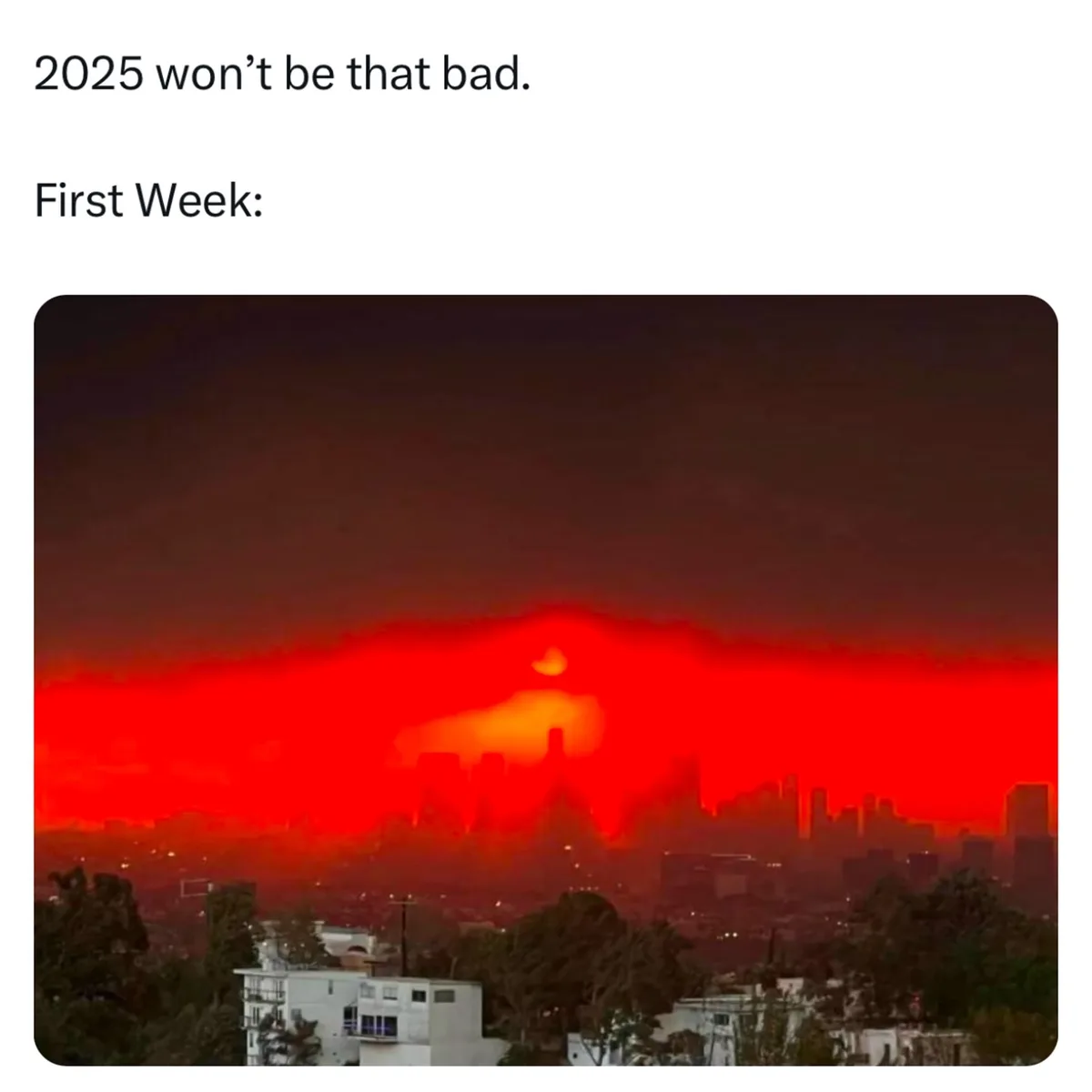 The image shows a city skyline under a sky saturated with red-orange hues, suggesting heavy smoke or pollution, with a faint…