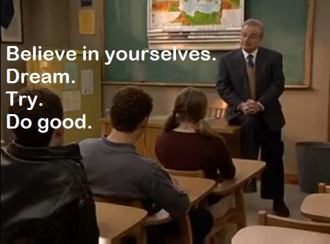 A classroom scene with a teacher standing at the front addressing students seated at desks. The teacher is wearing a suit…