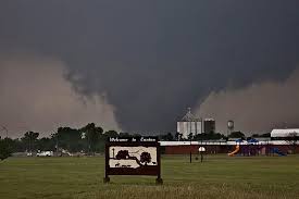 A dark, ominous storm cloud looms over a rural landscape featuring a sign that reads 'Welcome to Zombie' with a silhouette…