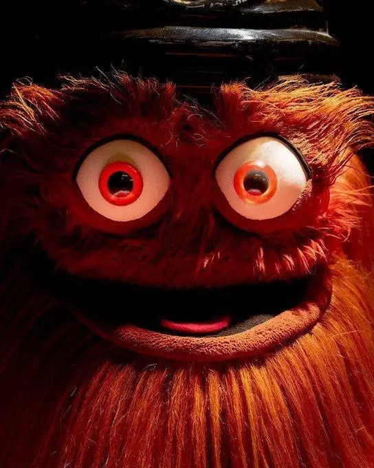 A close-up of the red, furry puppet character from 'Fraggle Rock' with wide, bulging eyes and a slightly open mouth…