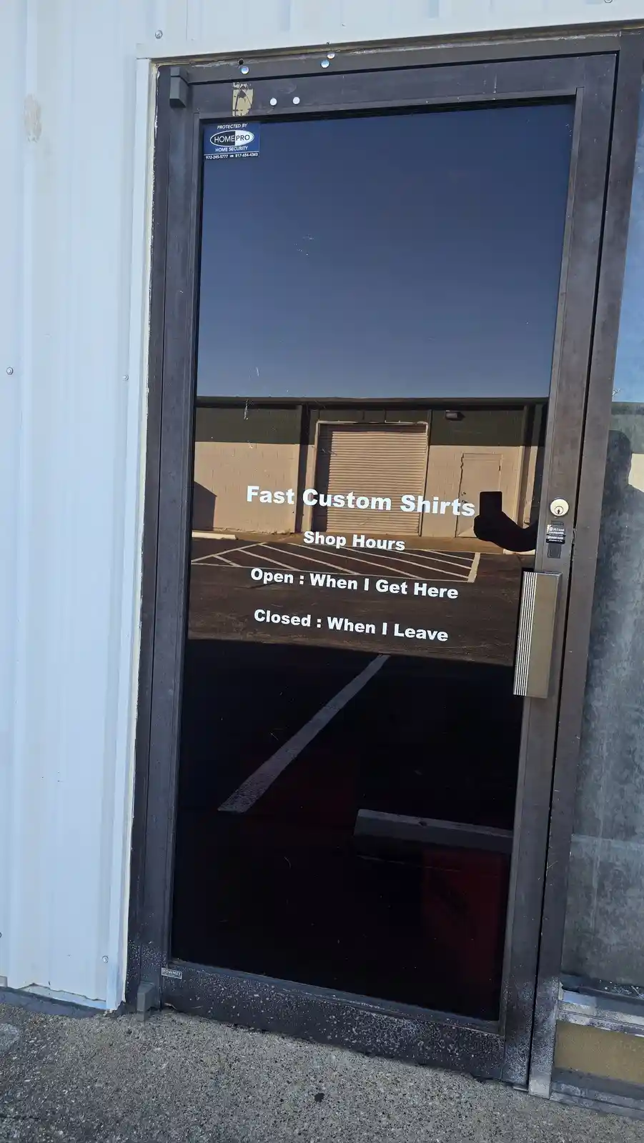 A photo of a glass door to a business called 'Fast Custom Shirts' with white text overlaid. The text humorously states 'Shop…