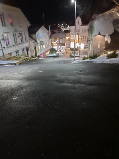 A nighttime photo of a quiet, snow-dusted street with buildings and streetlights, overlaid with the text 'i'm not lazy, i'm…