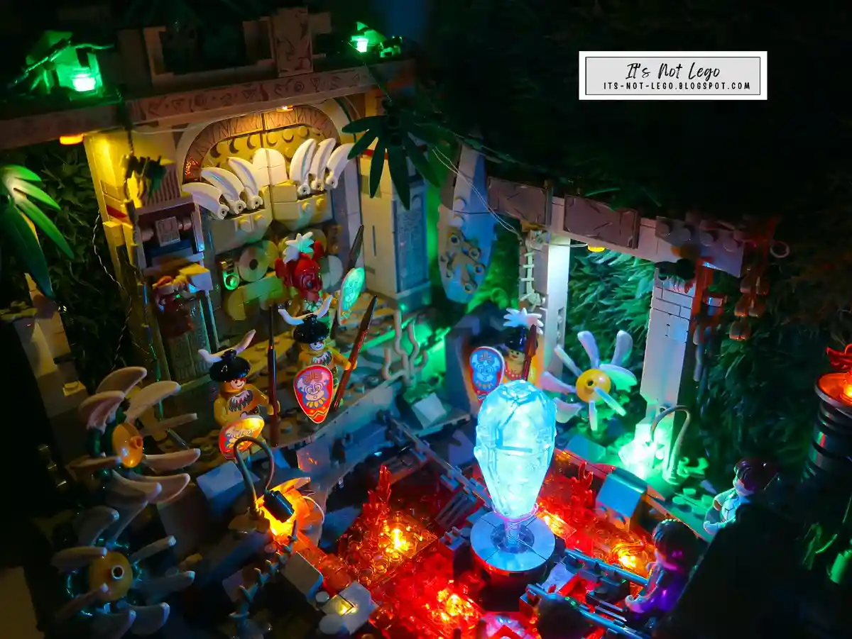 A detailed, illuminated LEGO jungle temple diorama with multiple minifigures, glowing red and green lights, and decorative…