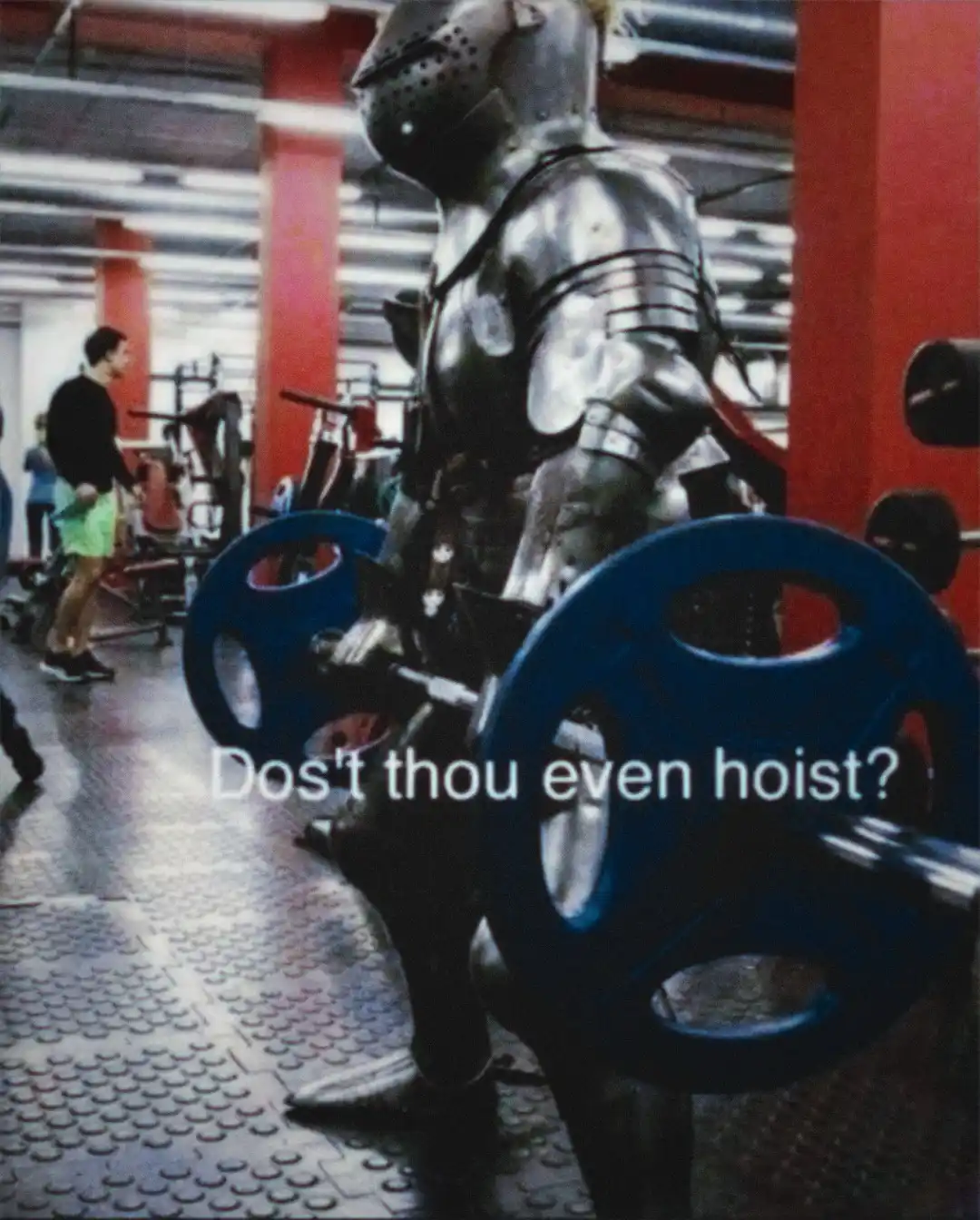 A person in full medieval knight armor is standing in a modern gym, holding a barbell with blue weight plates. The text…