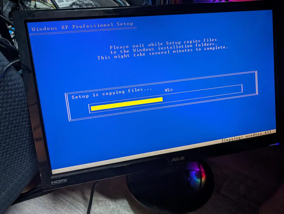 A photo of a computer monitor displaying the Windows XP Professional Setup screen, showing a progress bar at 45% while…