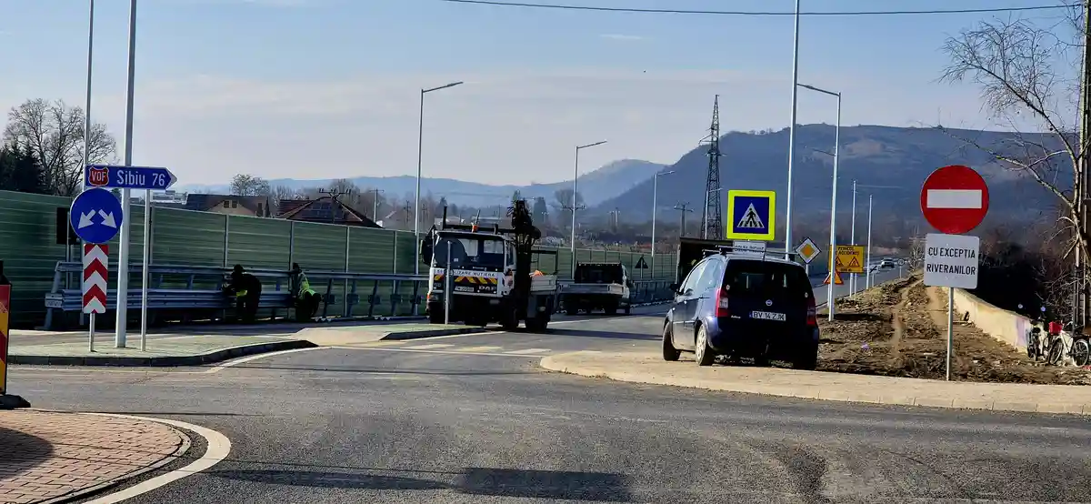 A road scene with construction workers, a road sign reading 'CU EXCEPTIA RIVERANILOR' (Except for riverbank residents) below…