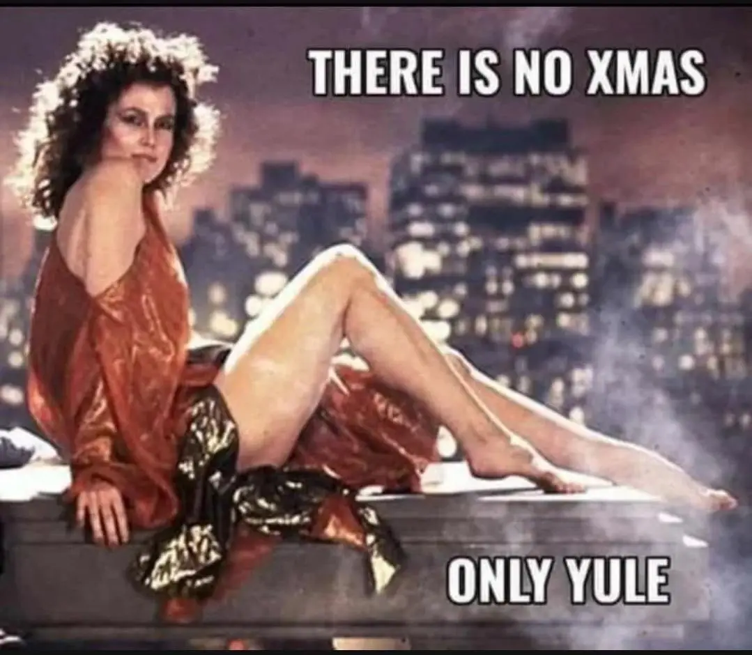 A woman with curly hair in a red and gold outfit sits on a rooftop with a city skyline behind her. The text overlaid on the…