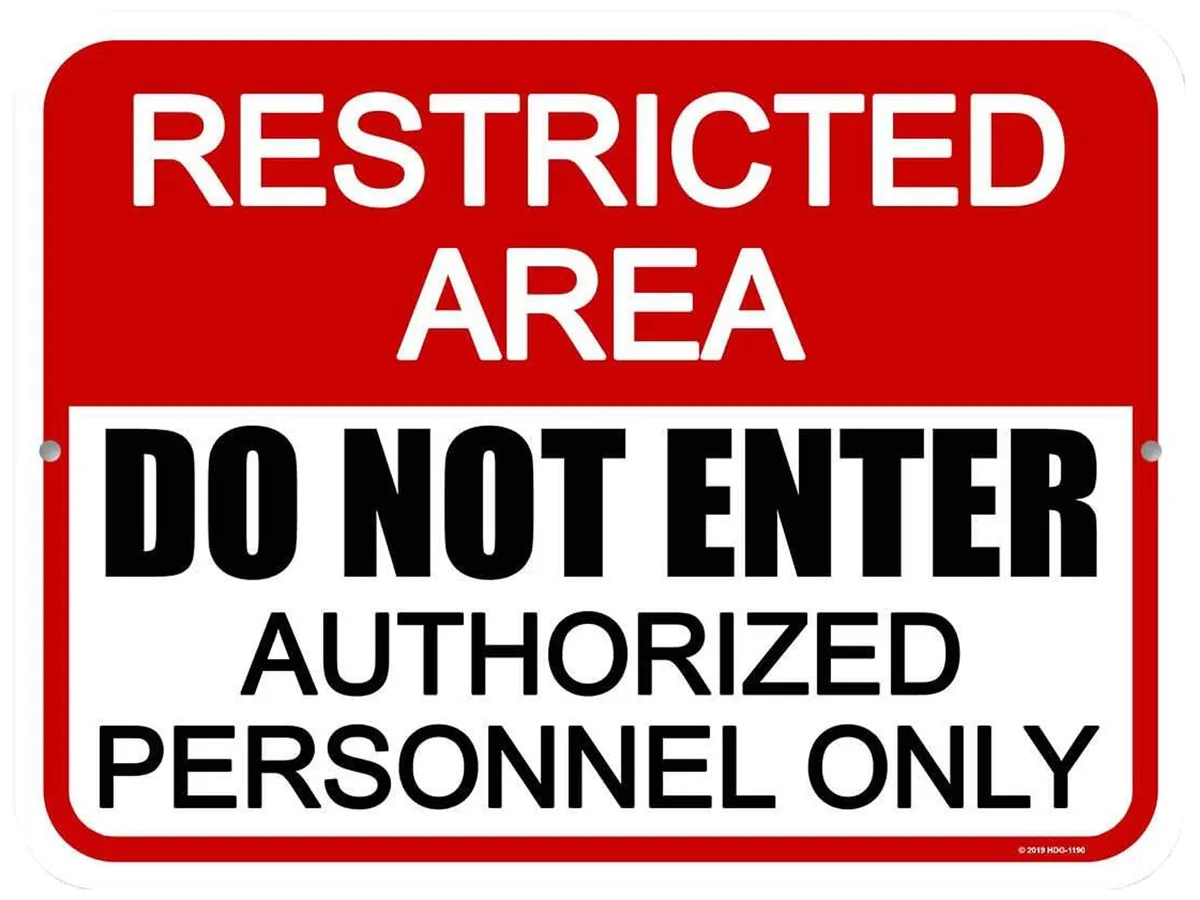 A red and white rectangular sign with bold text reads 'RESTRICTED AREA' at the top, followed by 'DO NOT ENTER' and…