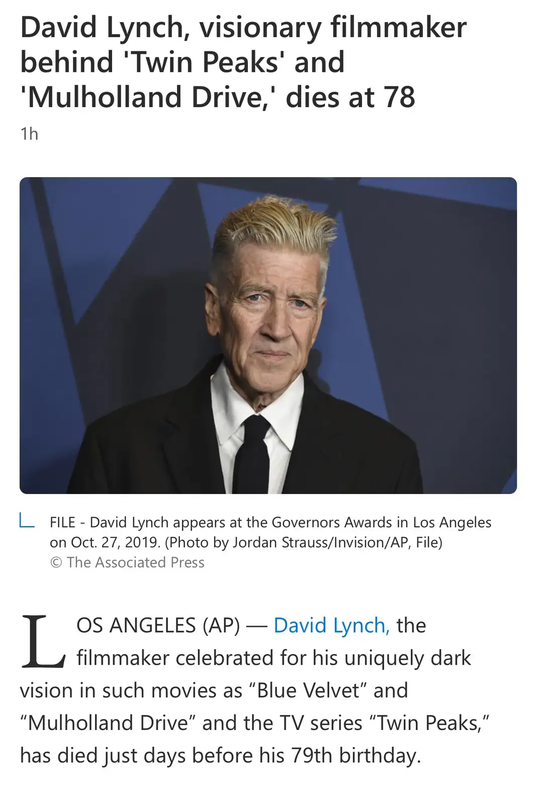 A news article screenshot shows a photo of David Lynch in a black suit and tie against a blue geometric background. The…