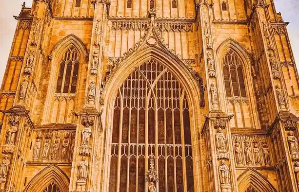A low-angle photo of a grand, ornate Gothic cathedral facade with pointed arches, intricate stonework, and statues, overlaid…
