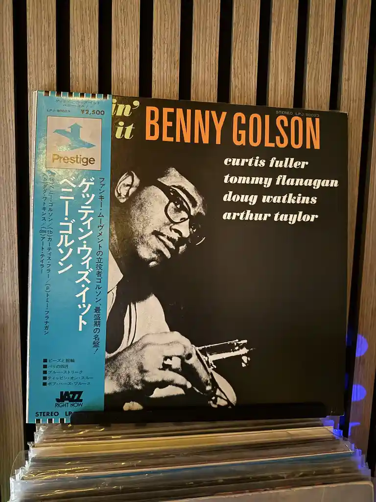 A vintage Benny Golson jazz album cover titled 'in' it' is displayed upright on a shelf, featuring a black-and-white photo…