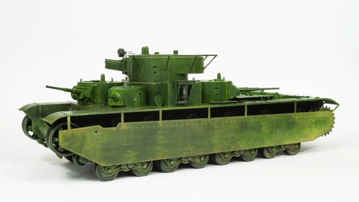 a detailed green model of a tank with multiple turrets and an unusually long, segmented hull, set against a plain white…