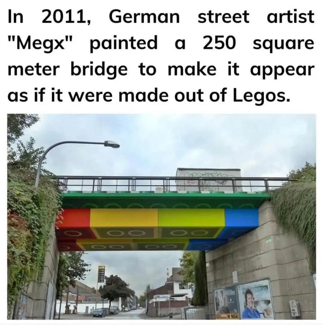 A photograph shows a concrete pedestrian bridge painted to resemble giant Lego bricks, with red, yellow, and blue sections…