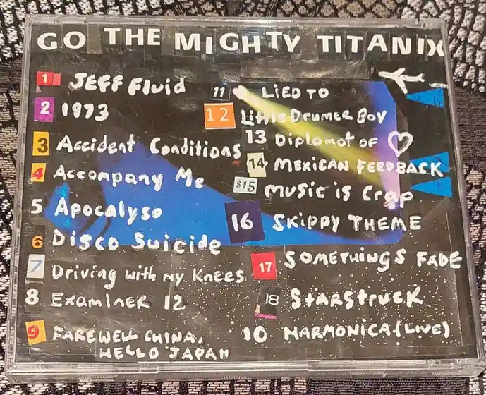 A handmade cassette tape cover for 'GO THE MIGHTY TITANIX' features a hand-drawn tracklist with song titles like 'Jeff…