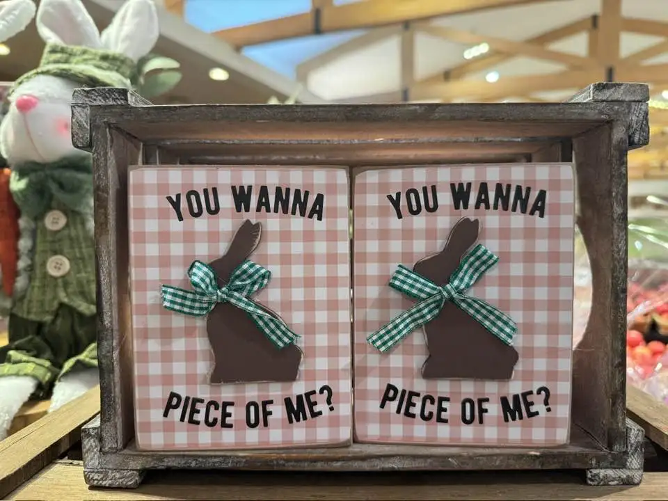 Two identical decorative signs in a wooden crate, each featuring a brown bunny silhouette tied with a green plaid ribbon…