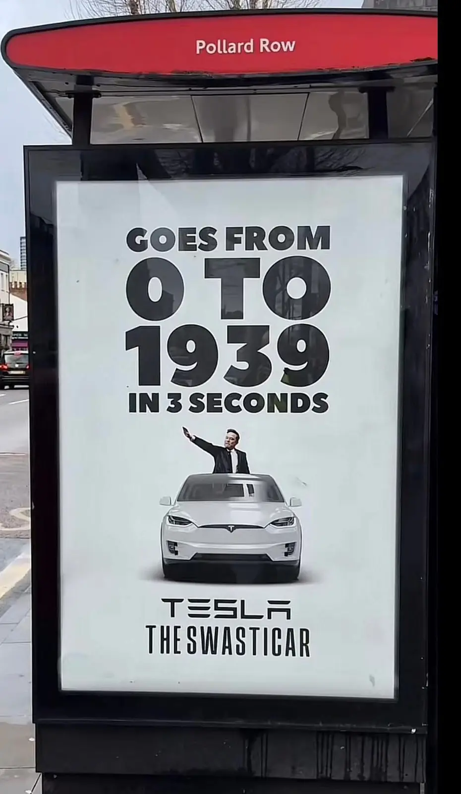 A bus stop advertisement for Tesla features a white Tesla SUV with a man in a suit waving from the roof. The ad claims the…
