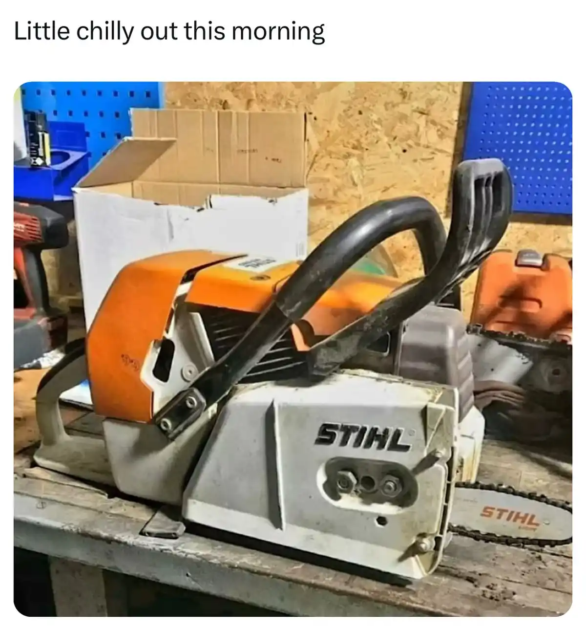 A STIHL chainsaw sits on a wooden workbench in a workshop, its orange and white body showing signs of use. The background…