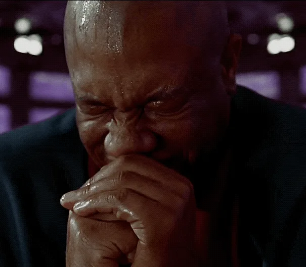 A six-panel image shows a bald man in a dark suit, visibly sweating and emotional, covering his mouth with his hands. His…