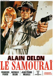 A vintage French movie poster for 'Le Samouraï' featuring actor Alain Delon in a trench coat and fedora, pointing a pistol…